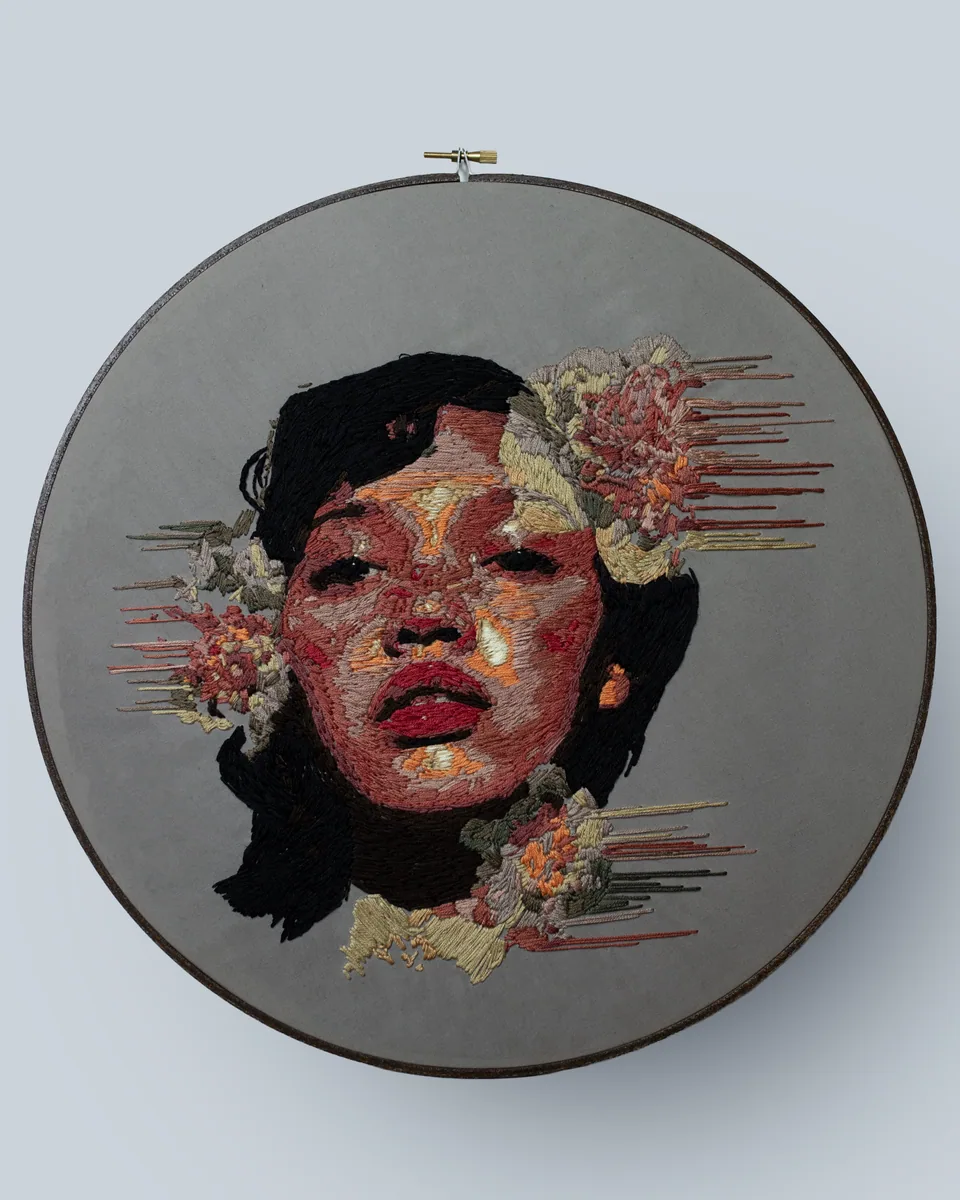 Colorful embroidered portrait surrounded by flowers