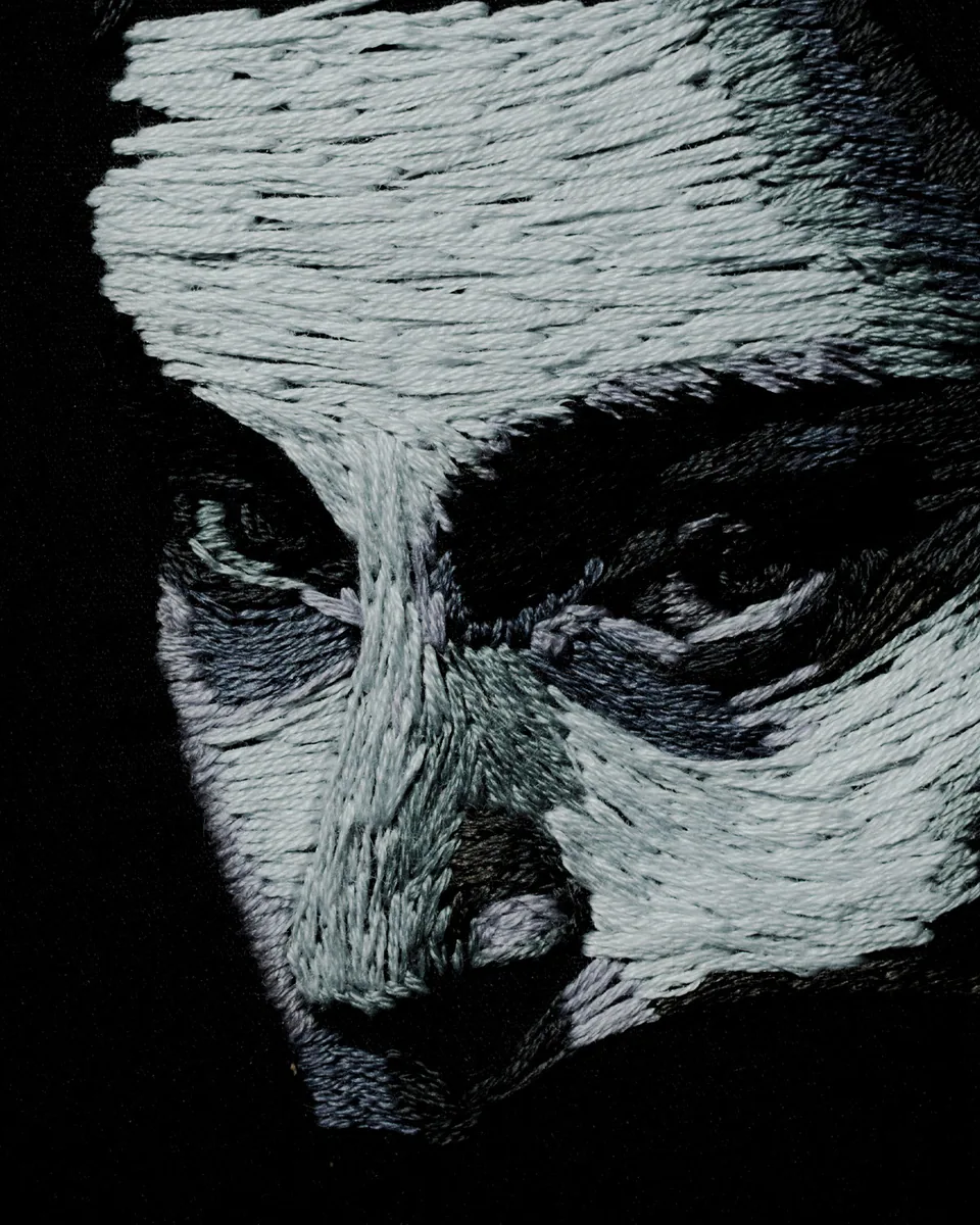 Close detail of the monochrome embroidered face