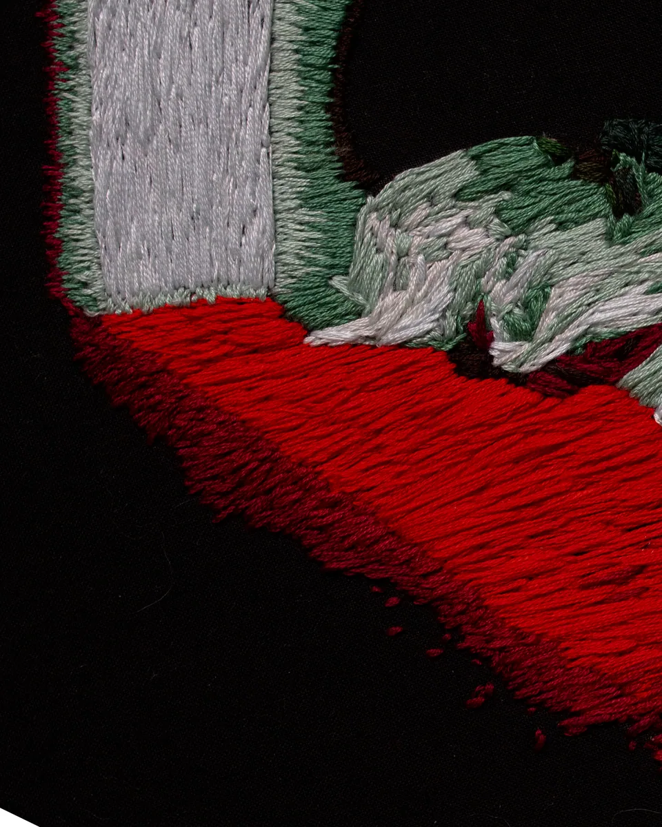 Close detail of red, green, and white stitching