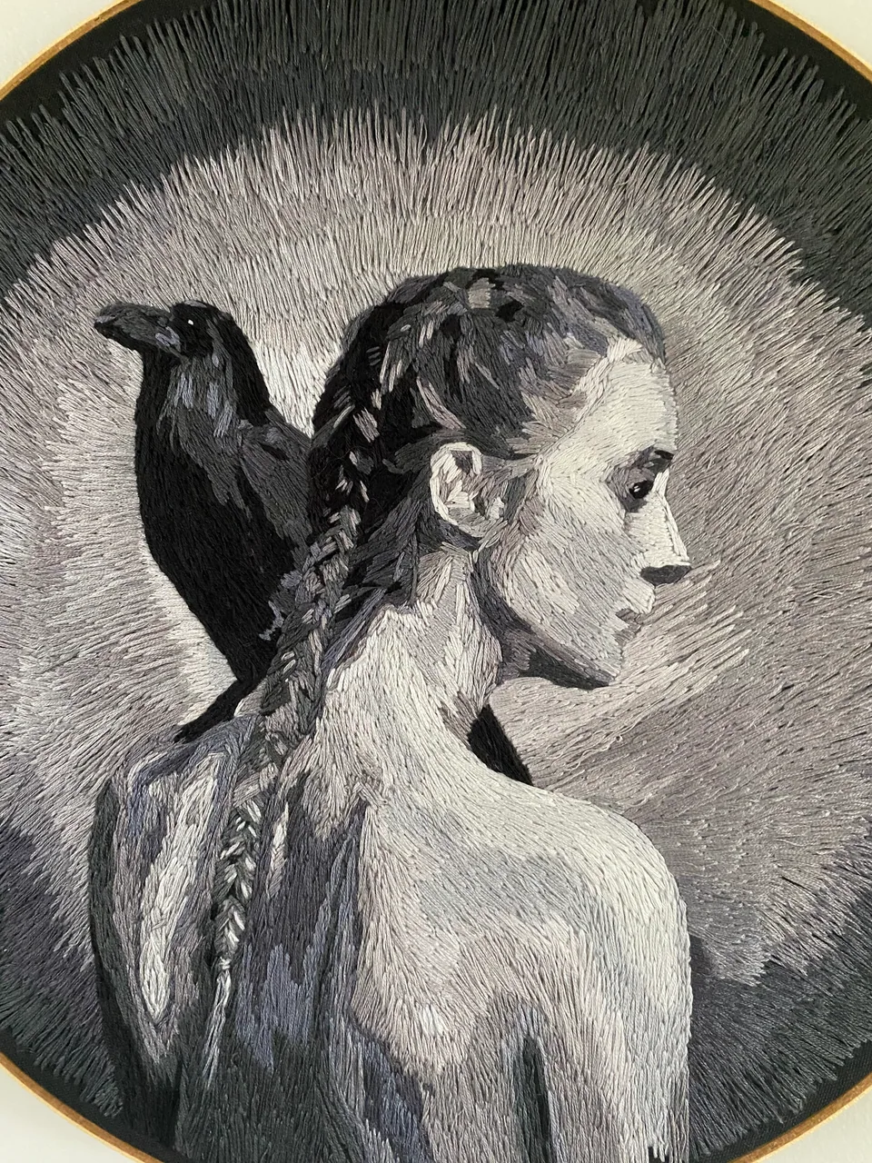 Close detail of the braided woman and raven embroidery